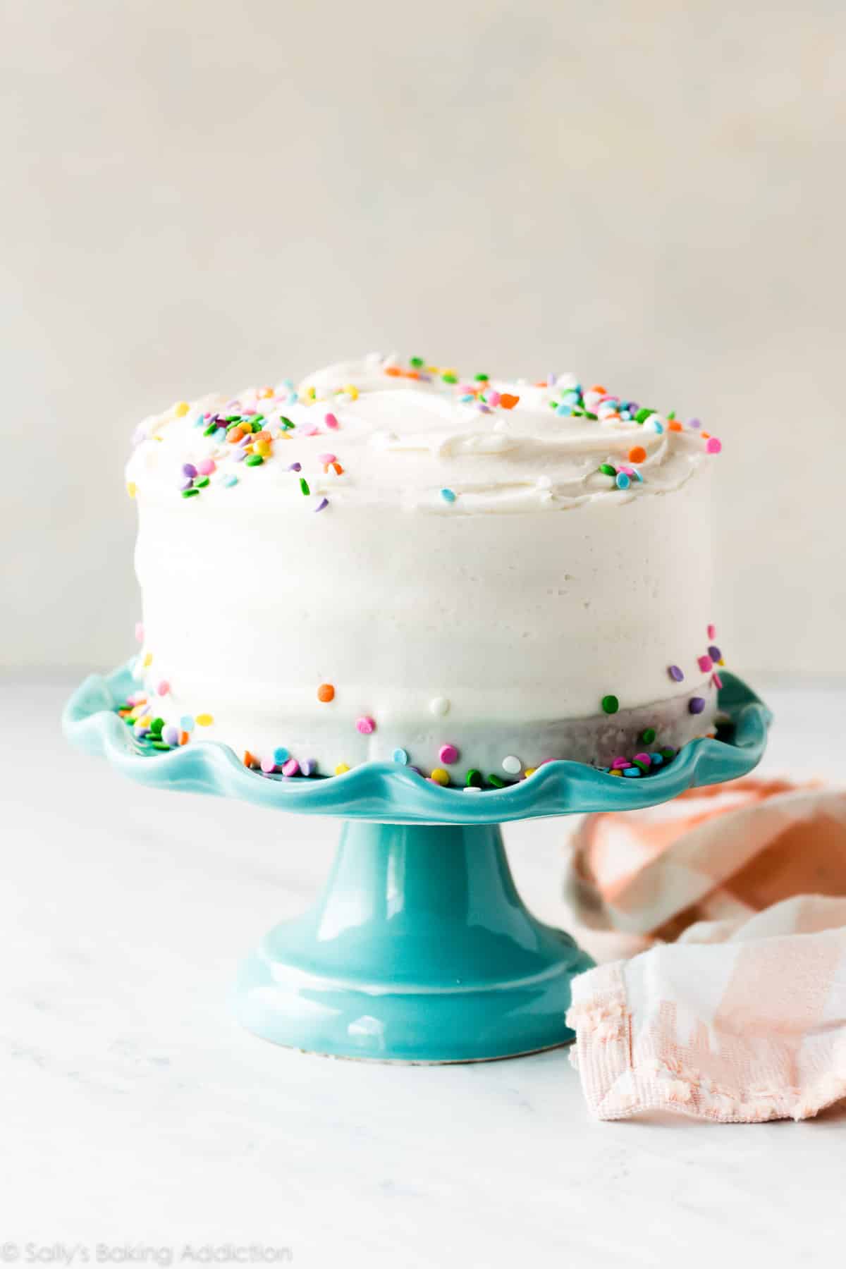 6 inch vanilla cake with sprinkles on a teal cake stand