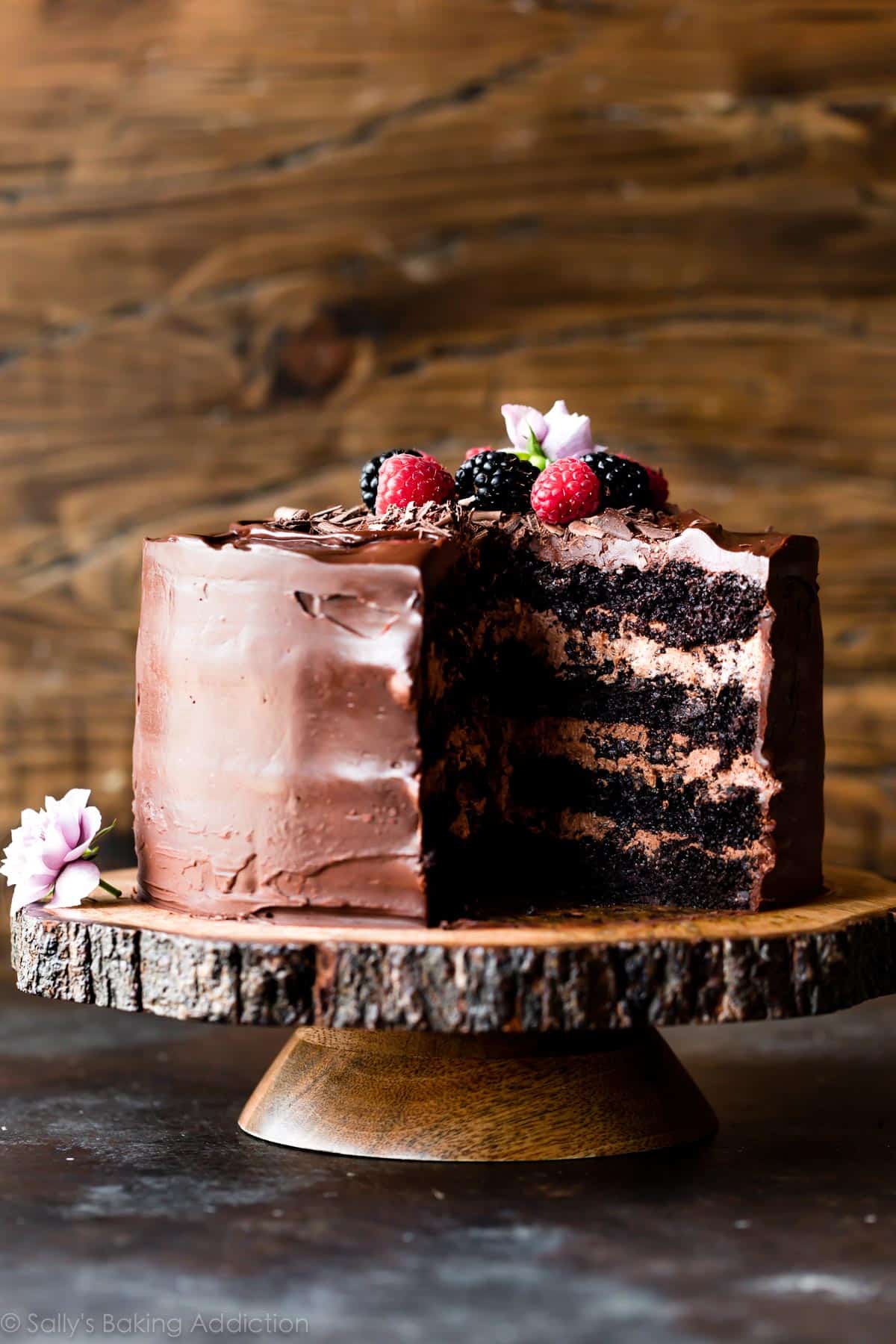 chocolate layer cake on a wooden cake stand