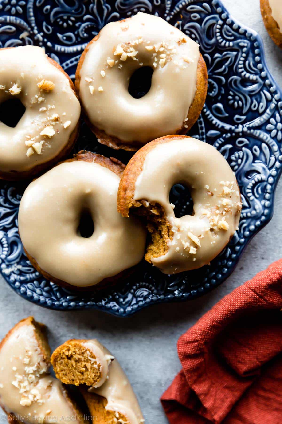 pumpkin donuts with icing on a blue plate
