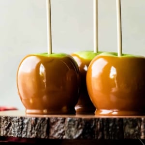 caramel apples on a wood slice cake stand
