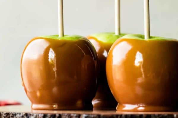 caramel apples on a wood slice cake stand