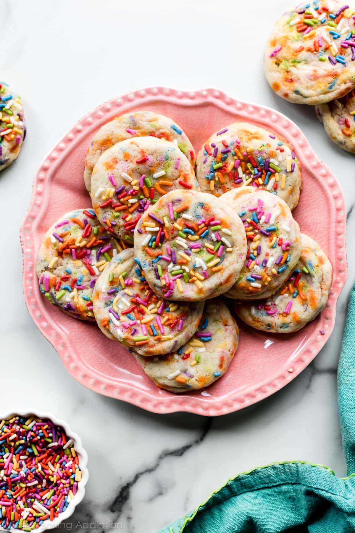 drop sugar cookies with sprinkles on a pink plate