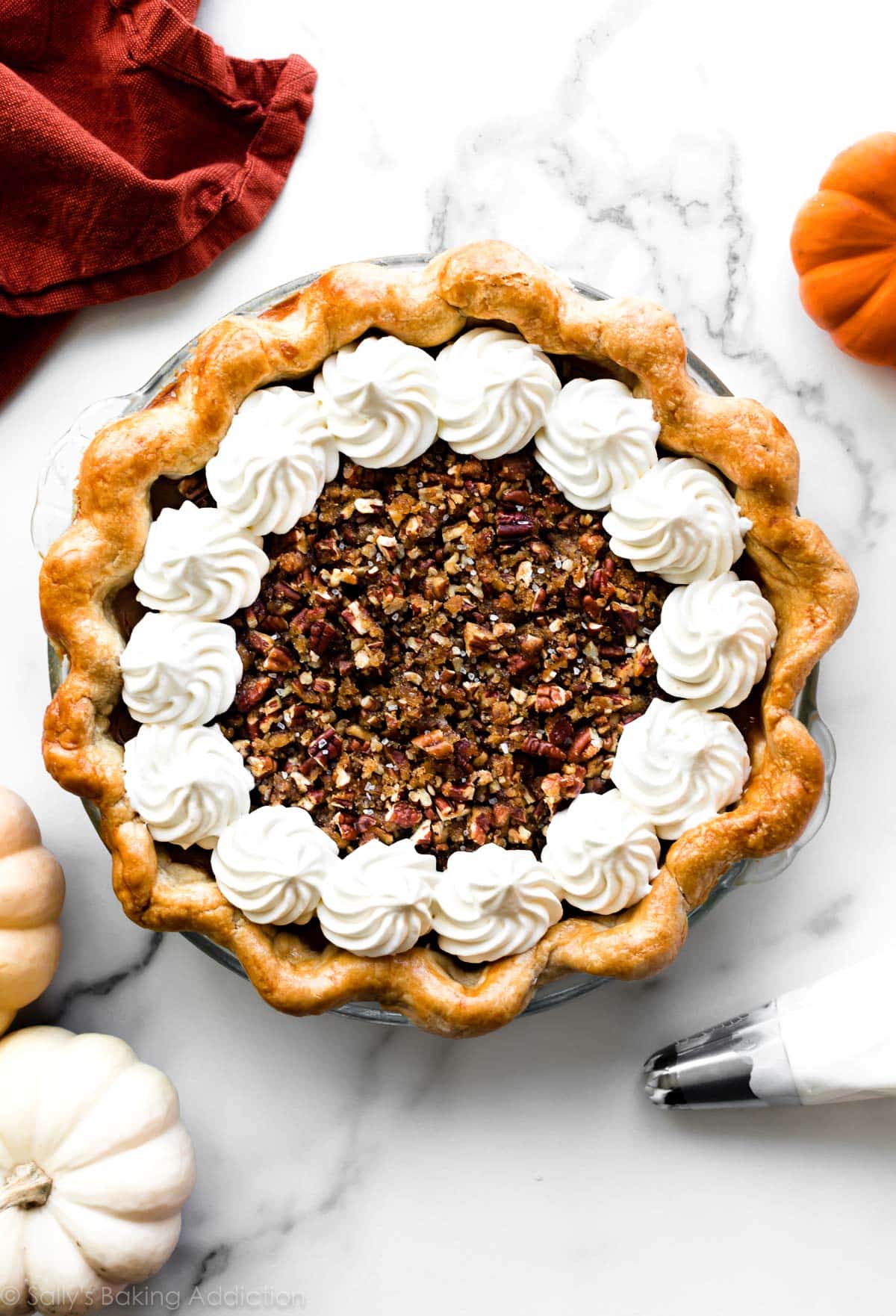 pecan pumpkin pie with whipped cream dollops