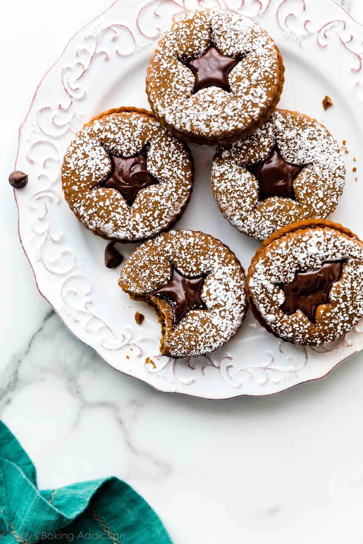 gingerbread sandwich cookies with chocolate ganache on a white plate