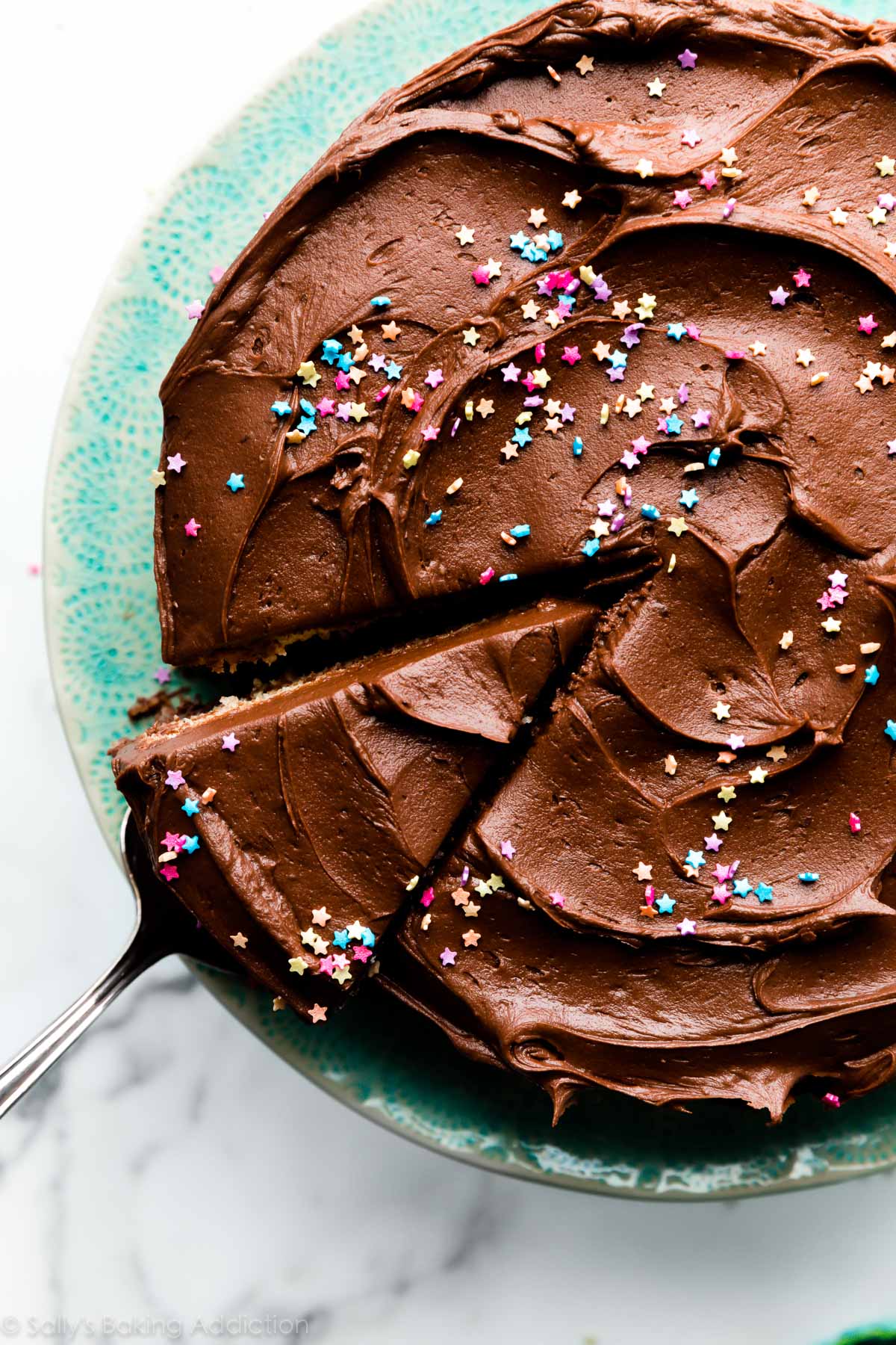 chocolate frosting and sprinkles on a yellow cake