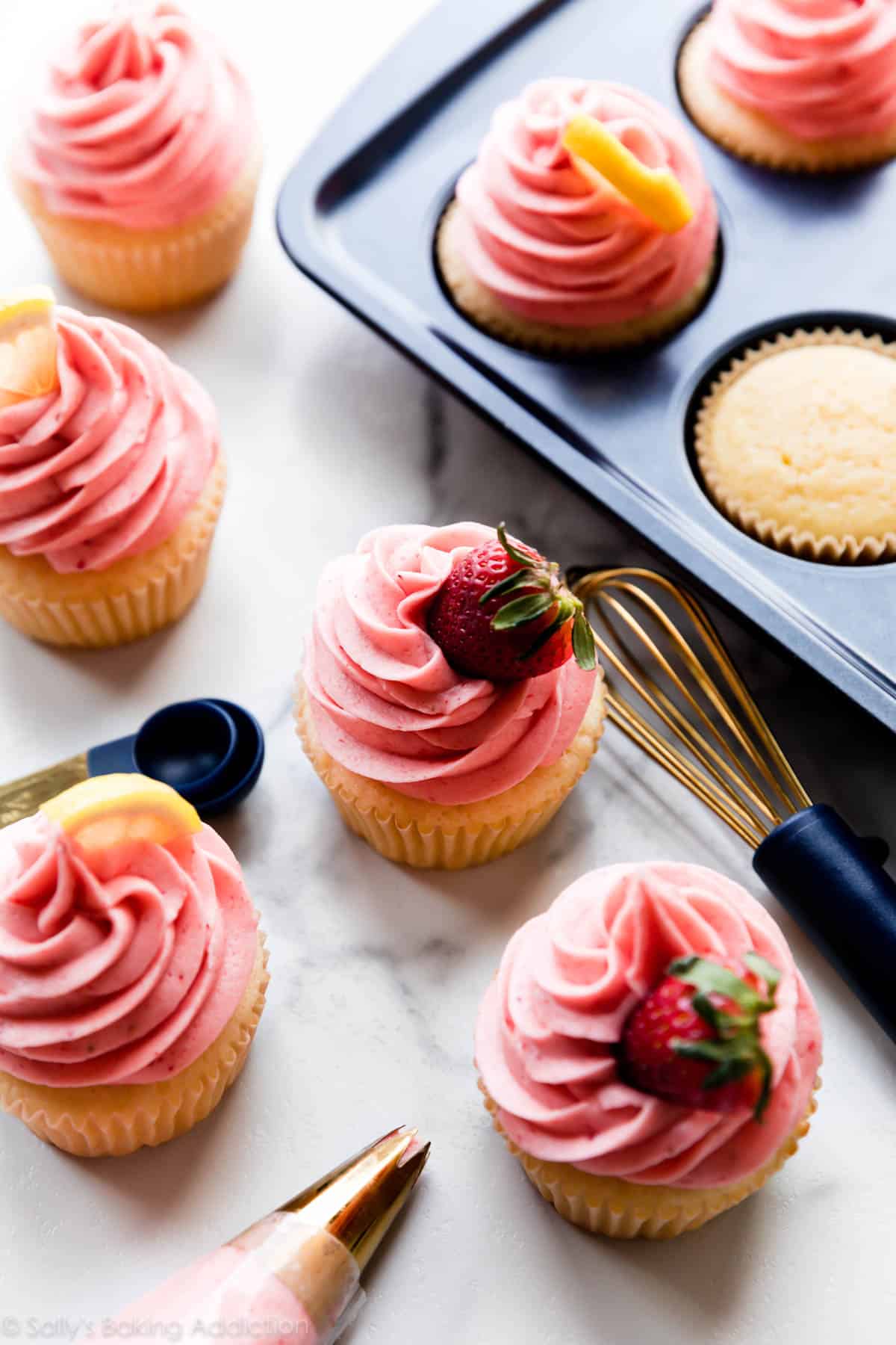 strawberry lemon cupcakes with strawberries and lemons used as garnish