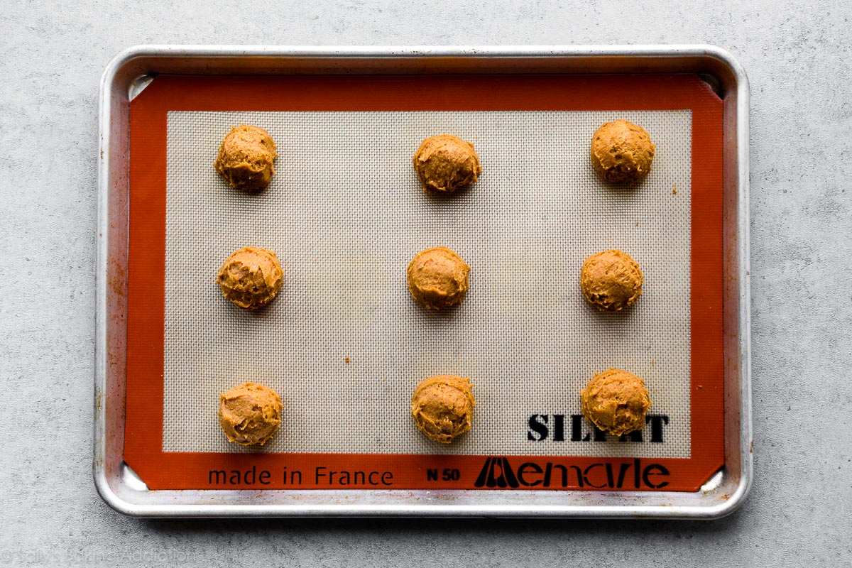 pumpkin cookie dough balls on baking sheet
