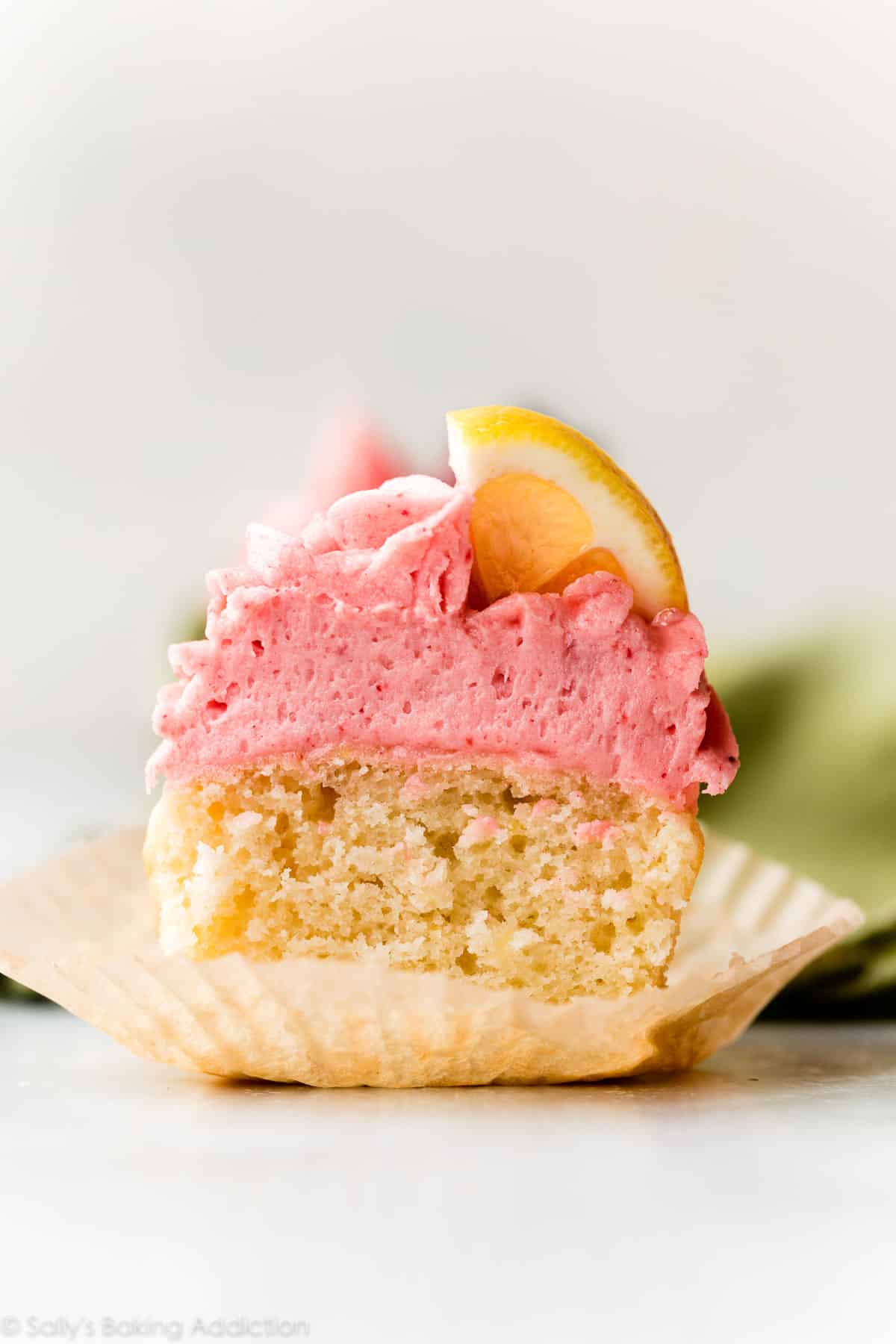 lemon cupcake with strawberry buttercream cut in half