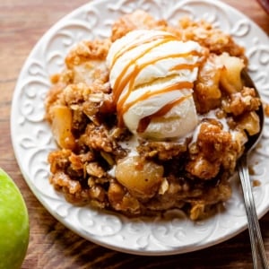 apple crisp serving with vanilla ice cream and caramel topping