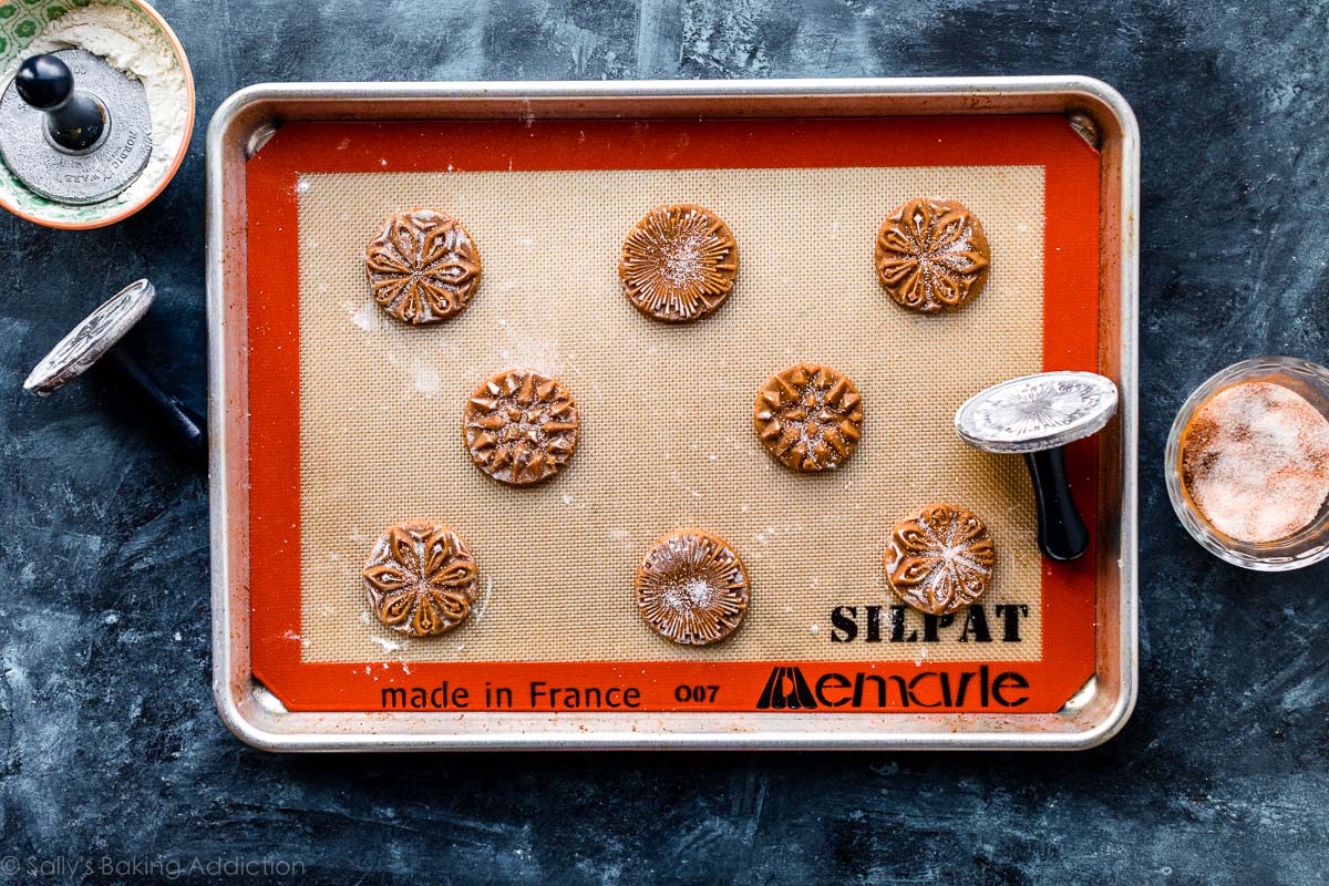 stamped cookies before baking spaced apart on a baking sheet