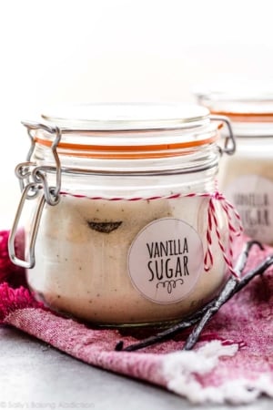 homemade vanilla sugar in a jar with vanilla beans on the side