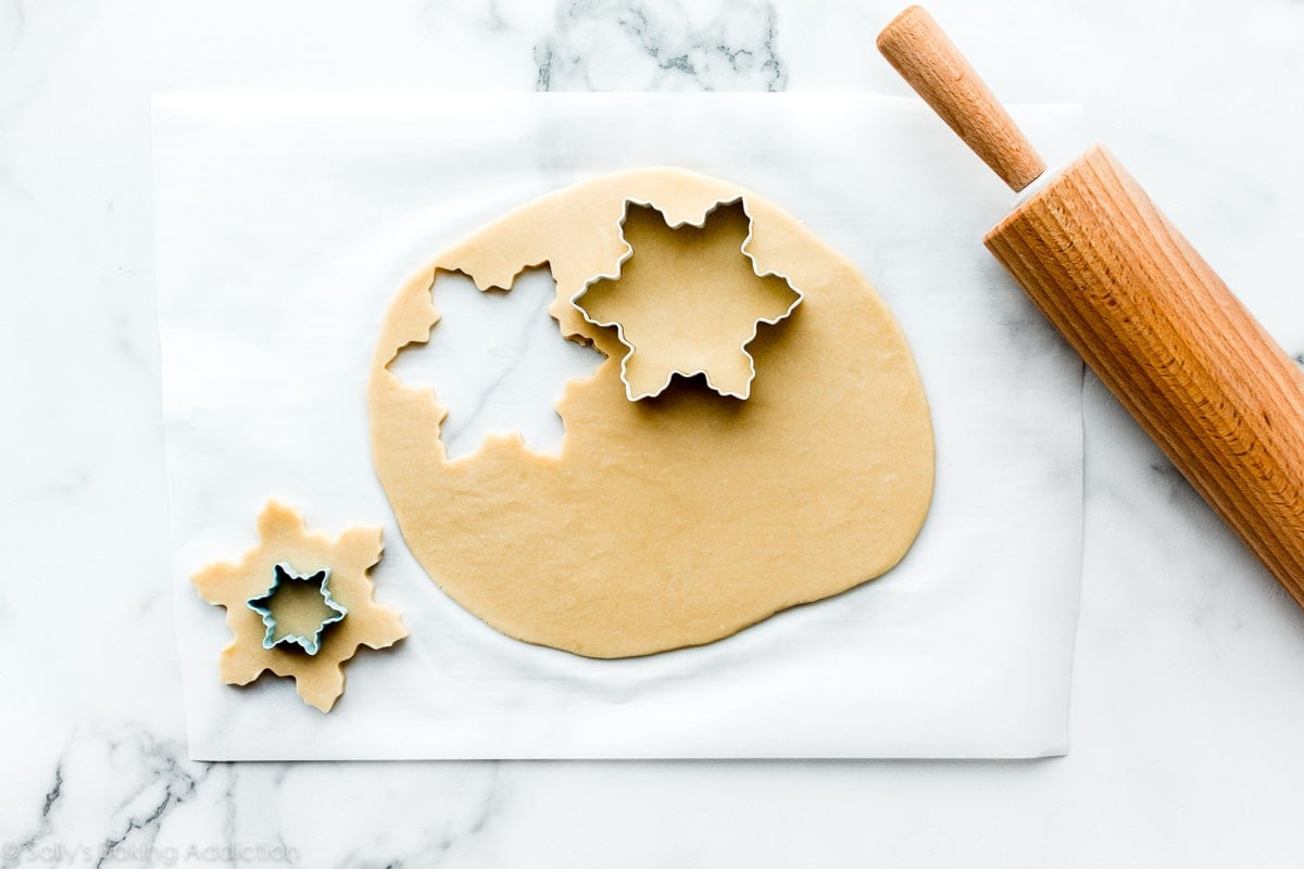rolled out sugar cookie dough with snowflake cookie cutters