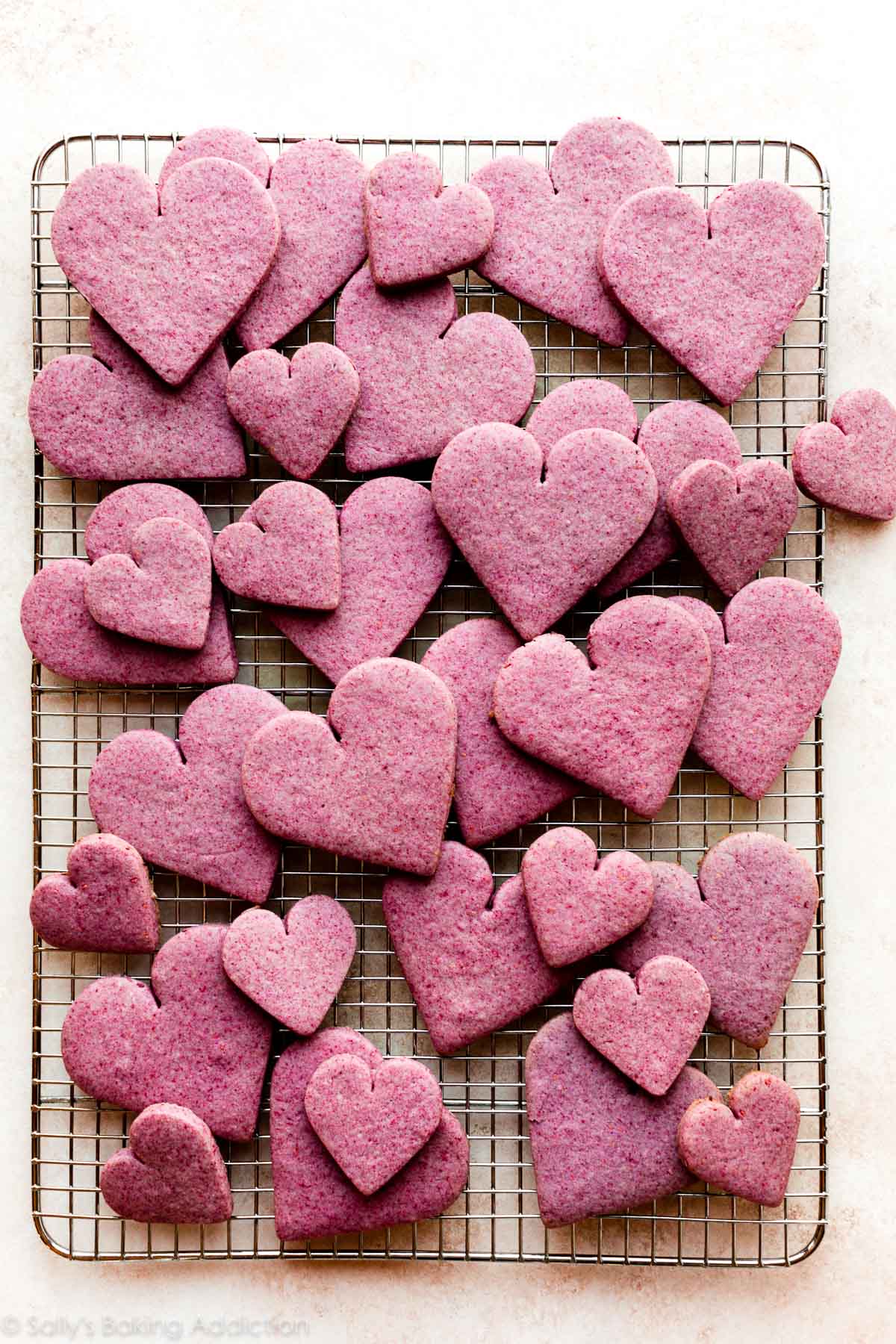 heart-shaped raspberry cookies on a cooling rack
