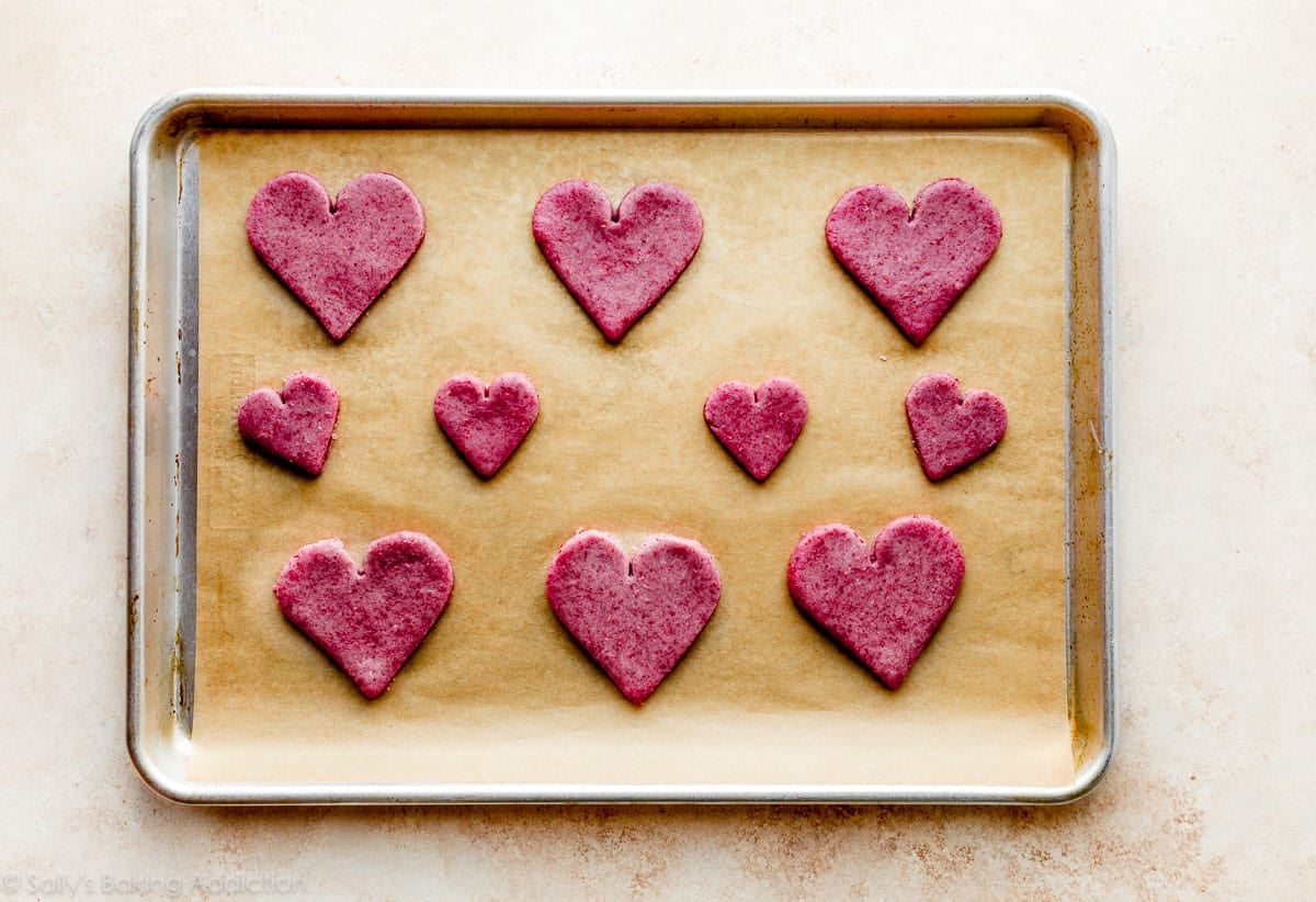 heart-shaped raspberry cookies on a baking sheet