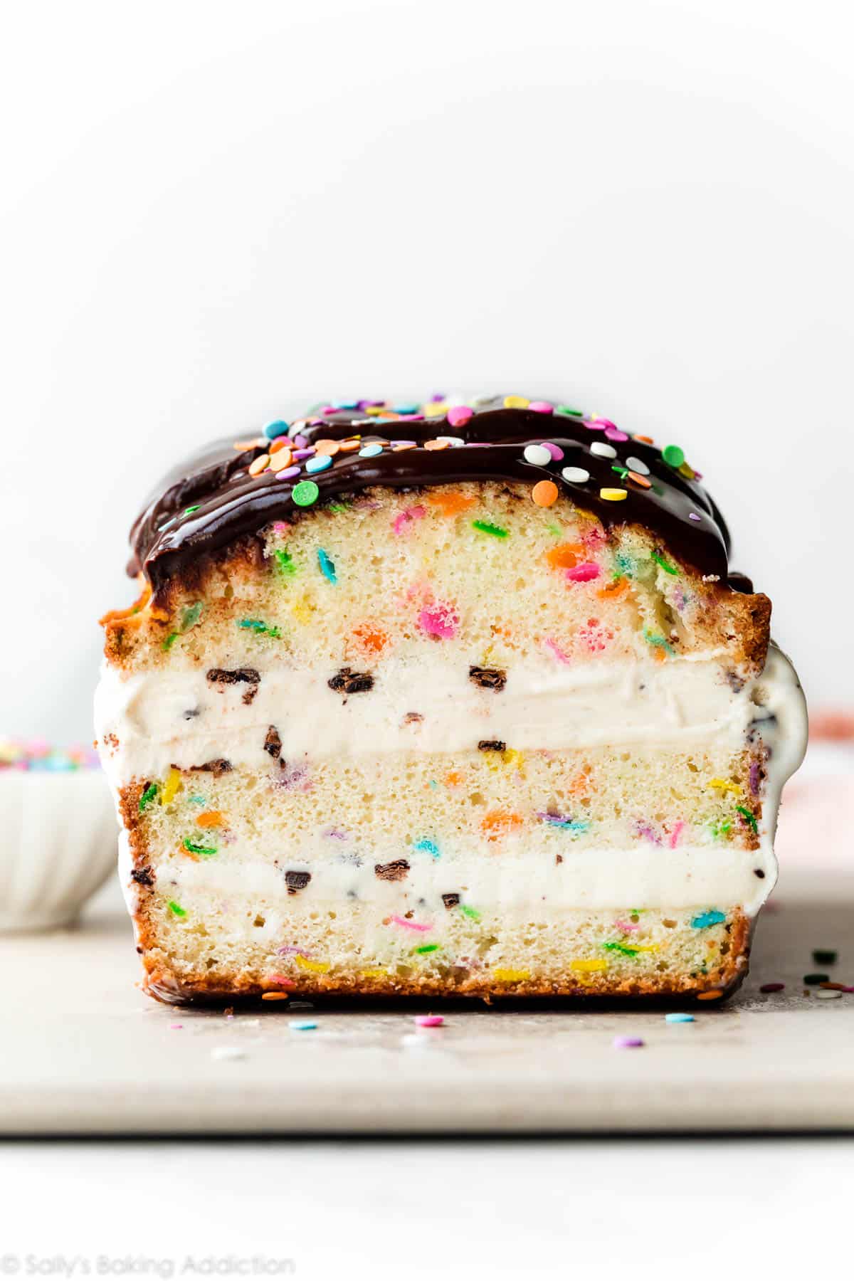 ice cream layered loaf cake with chocolate ganache and sprinkles