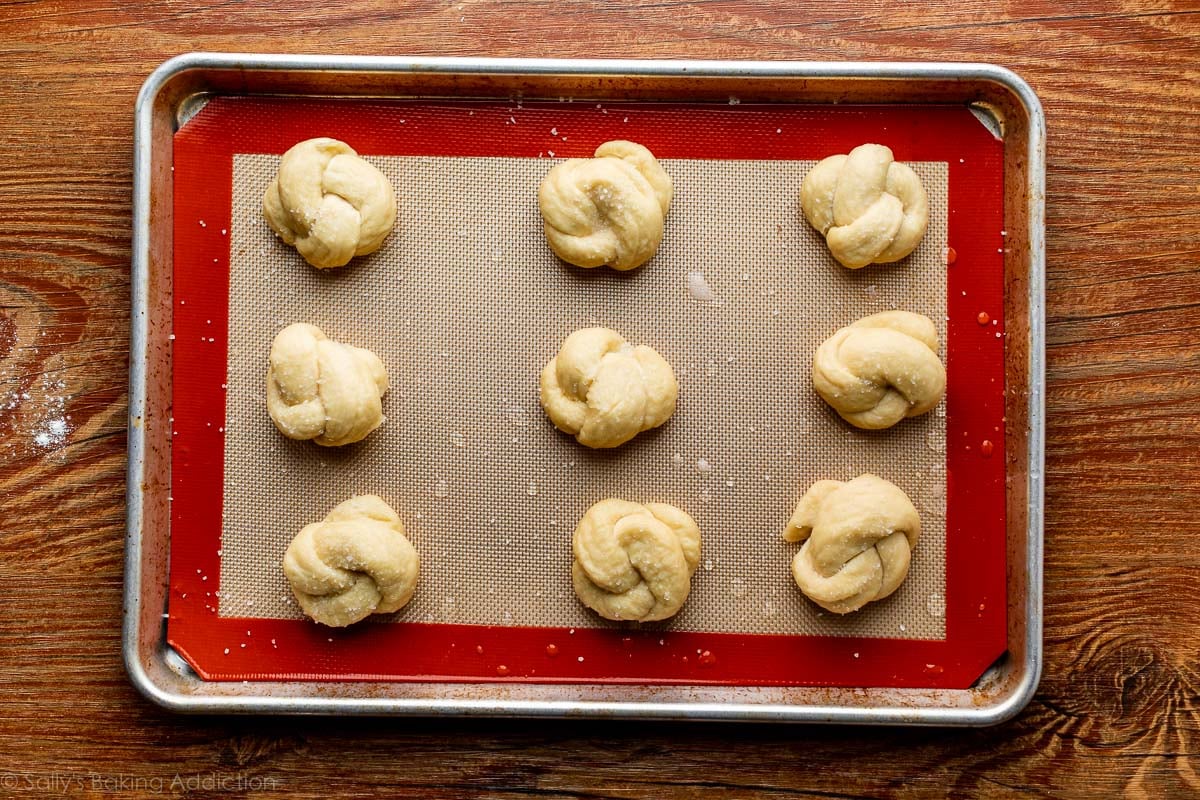 soft pretzel knots on baking sheet before baking
