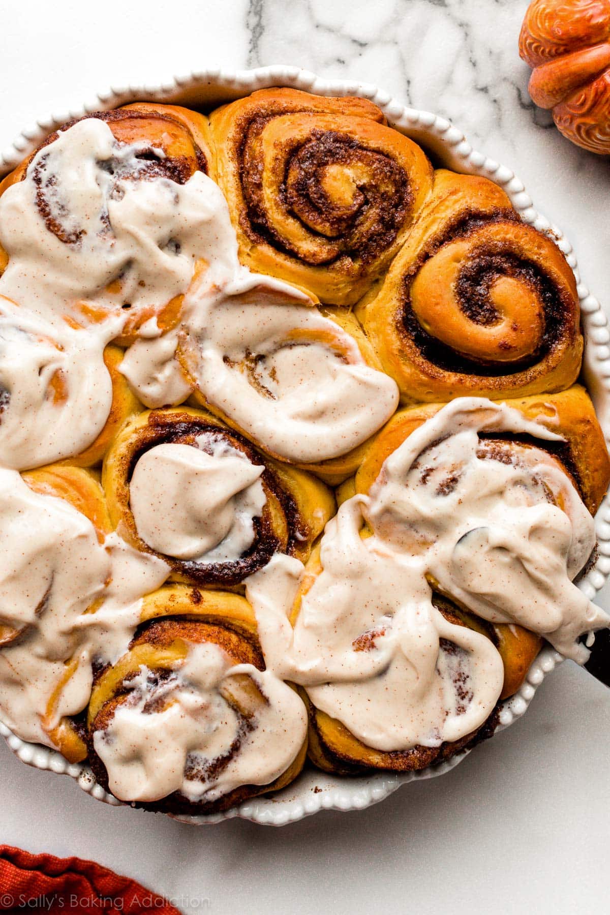 pumpkin cinnamon rolls in white baking dish