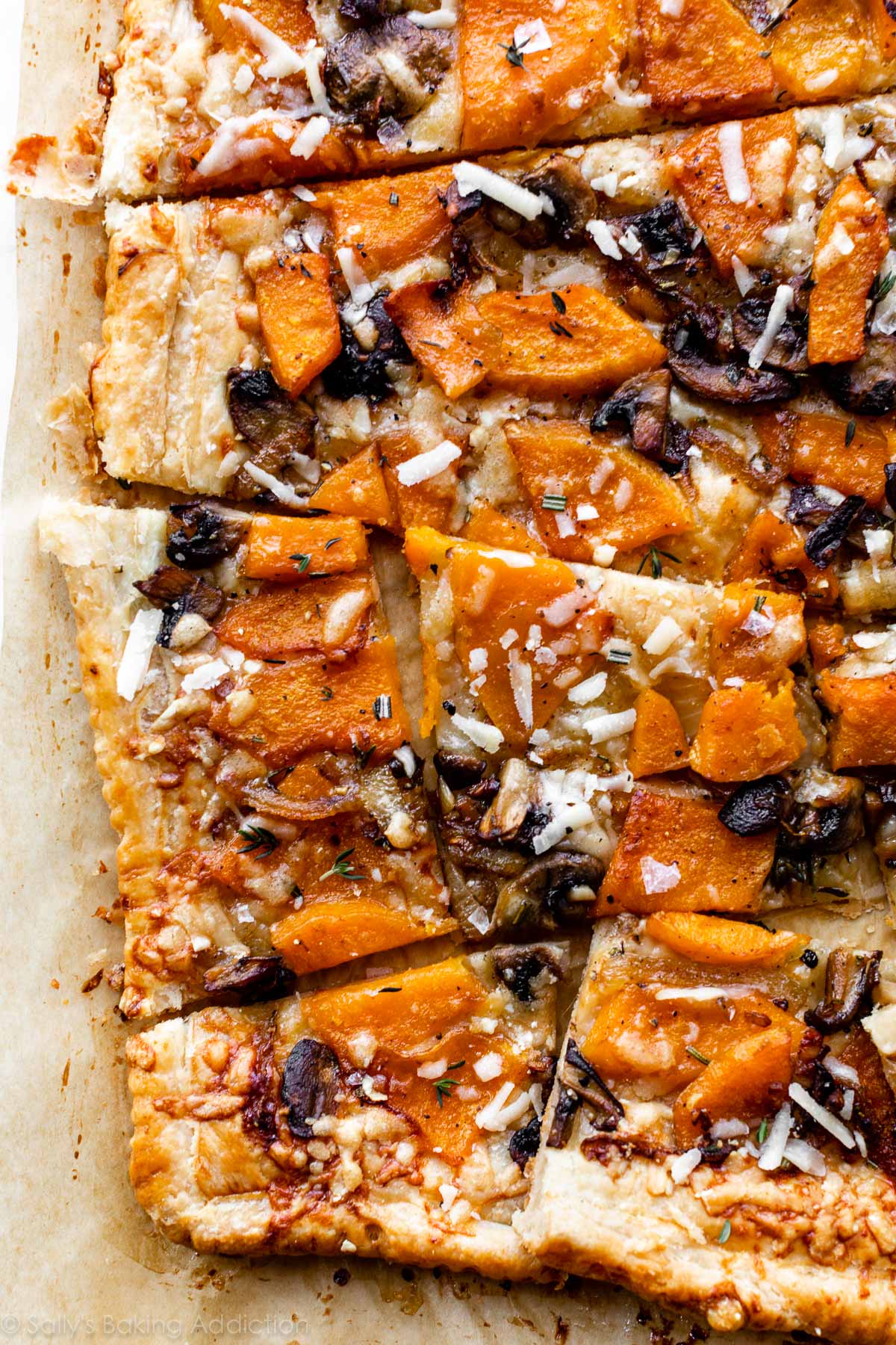 sliced butternut squash and mushroom tart with parmesan cheese