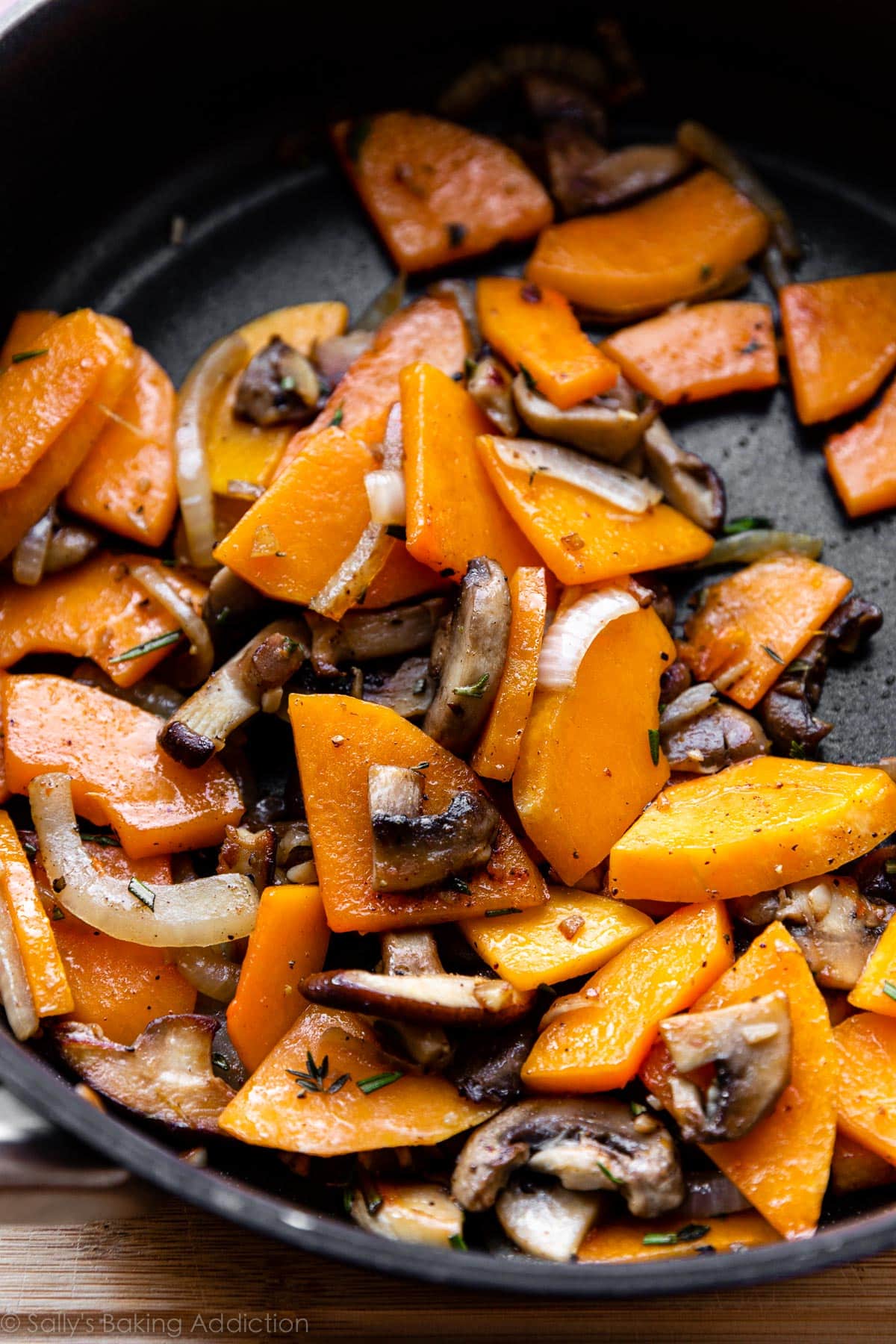 cooked butternut squash, onions, and mushrooms in skillet