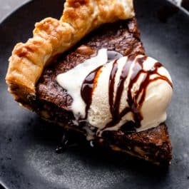 slice of brownie pie with vanilla ice cream and chocolate syrup