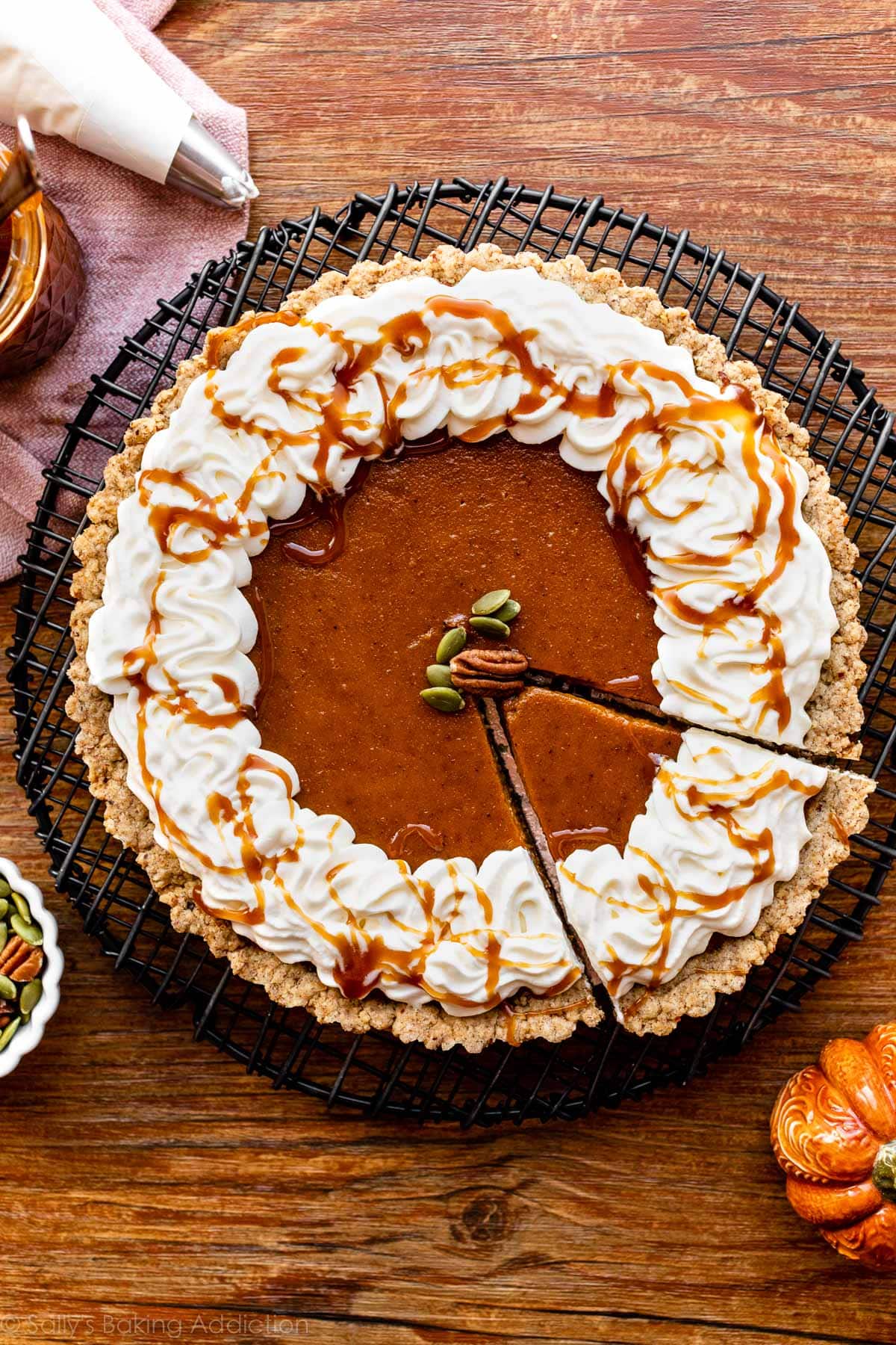 pumpkin tart with whipped cream, caramel, and pecan crust