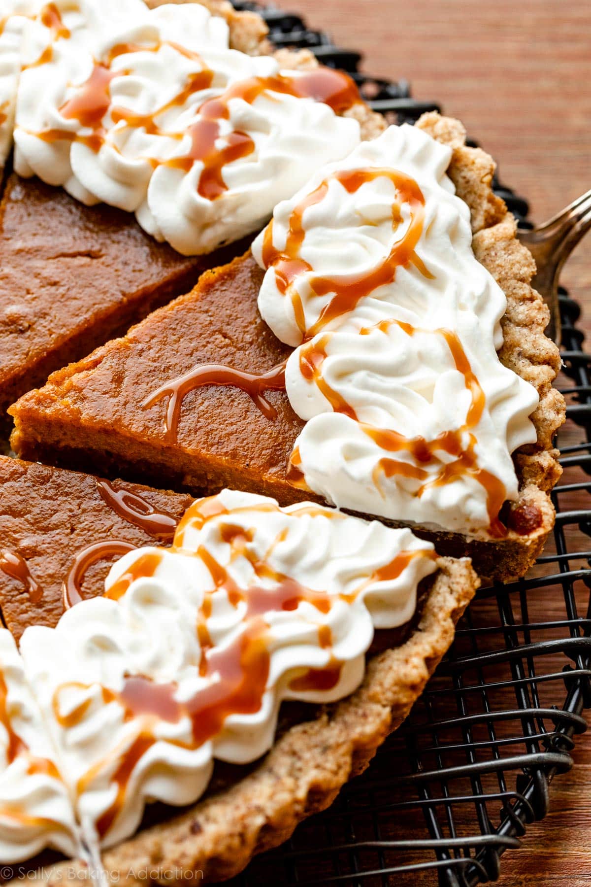 pumpkin tart slice with whipped cream and salted caramel on top
