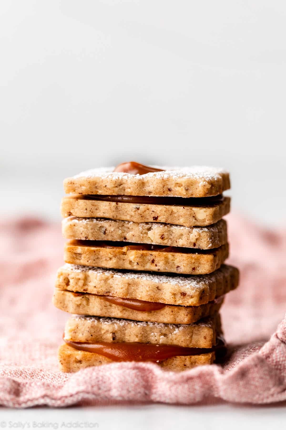 stack of linzer-style caramel hazelnut cookie sandwiches