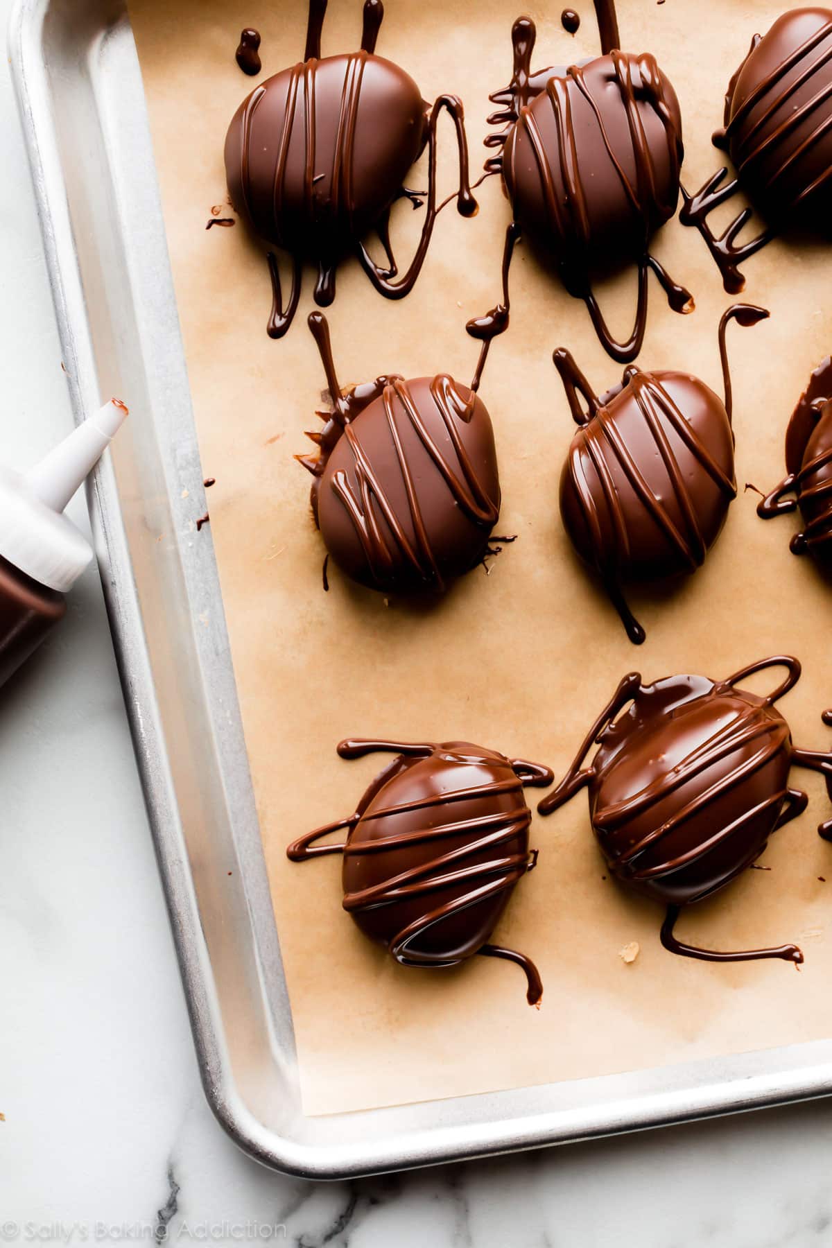 chocolate coated egg-shaped candies with chocolate drizzle on top