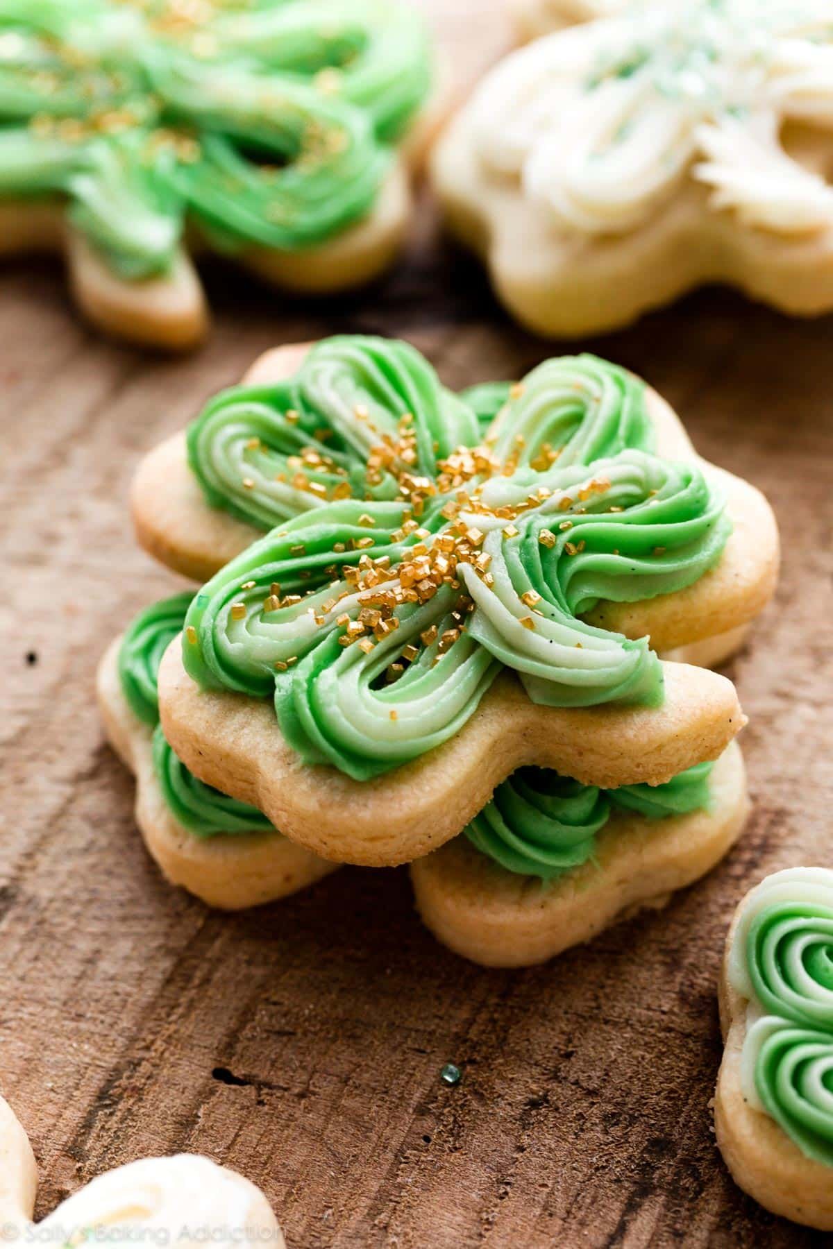 vanilla bean shamrock shaped cookies with St. Patrick's Day green buttercream and gold sprinkles