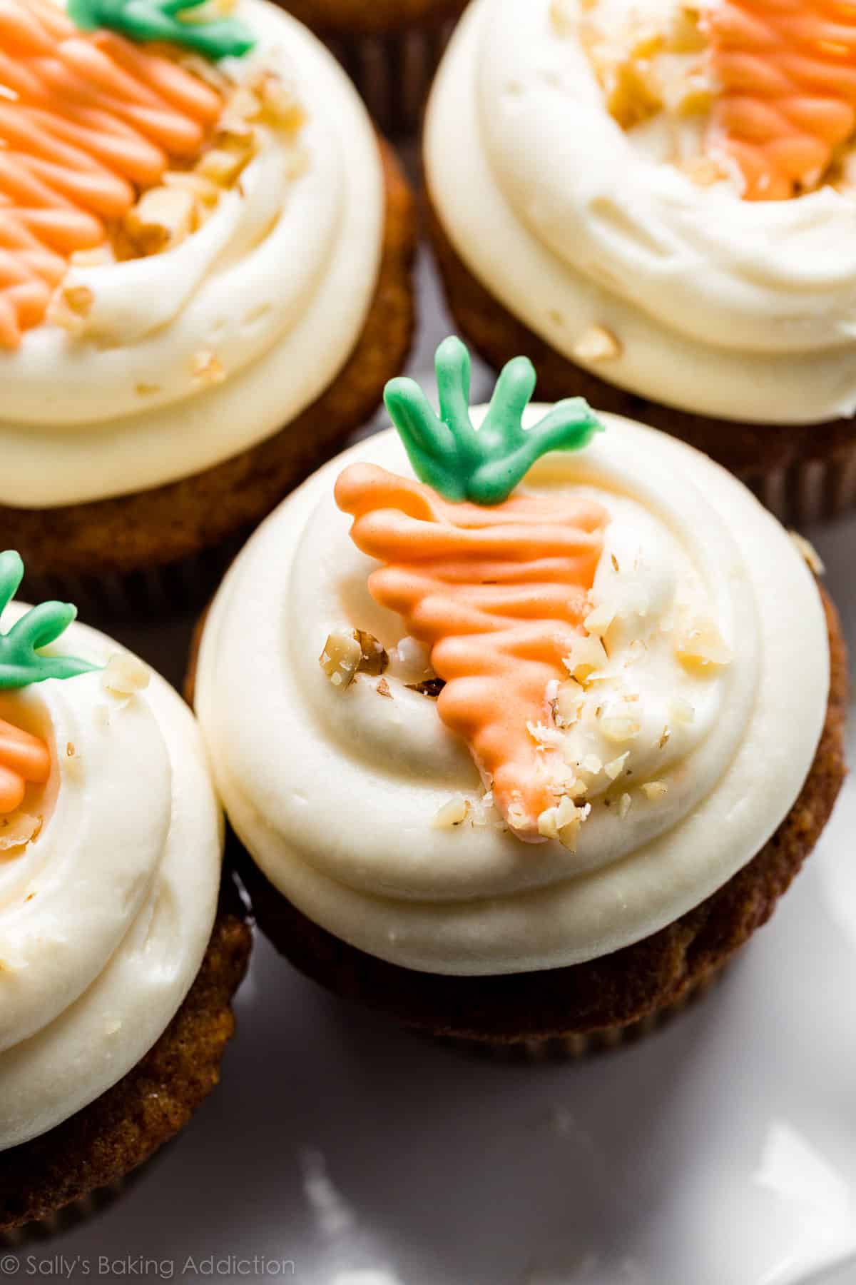 carrot cake cupcakes with white chocolate carrot garnish on top