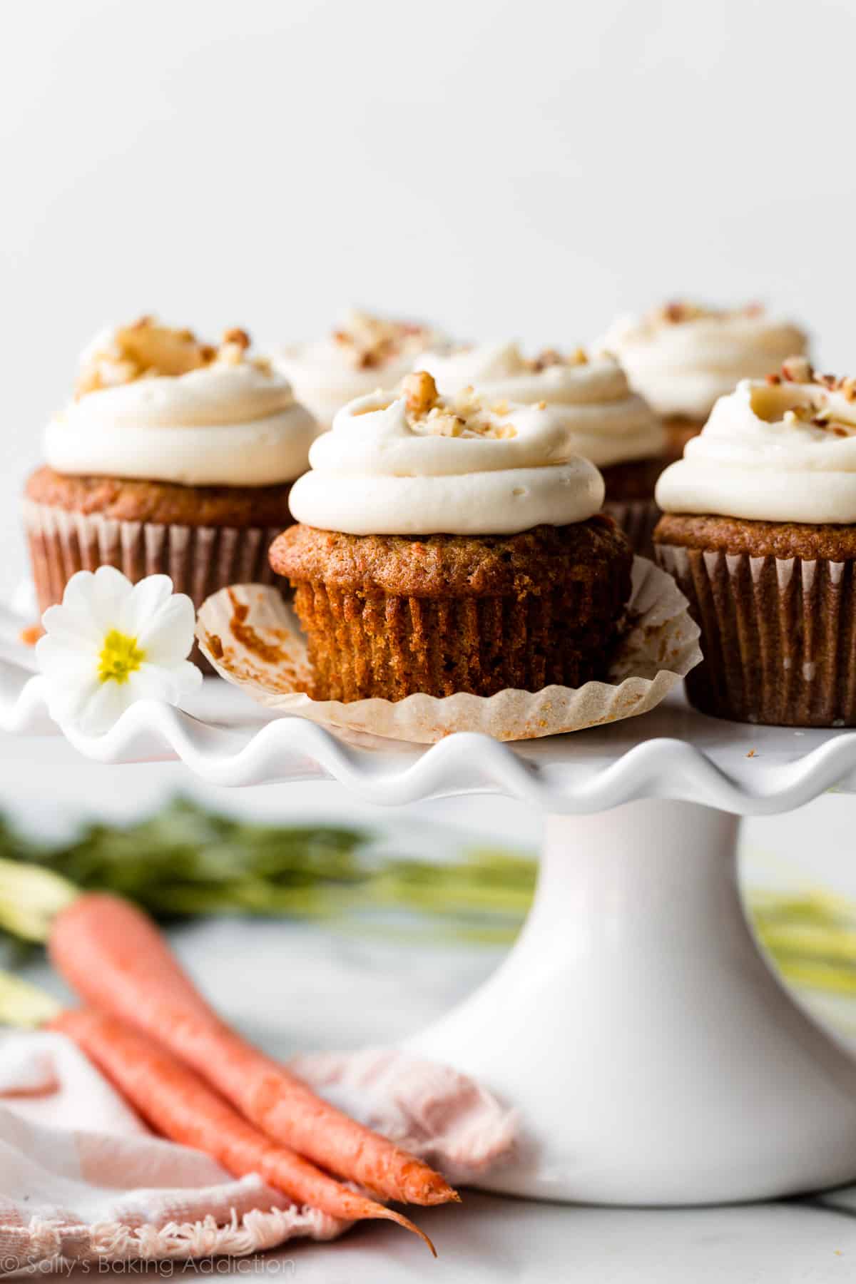 carrot cake cupcakes with cream cheese frosting on white cake stand