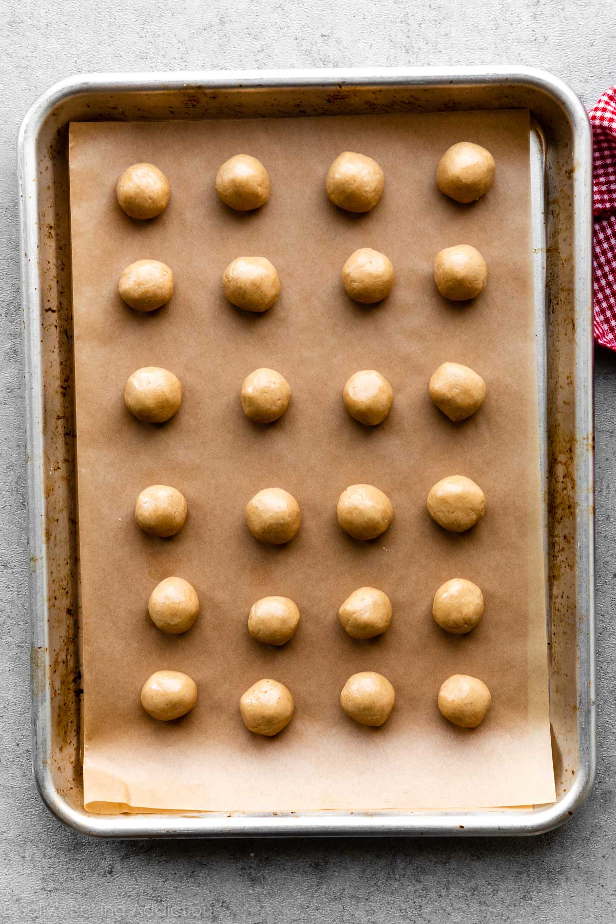 24 peanut butter balls on lined baking sheet
