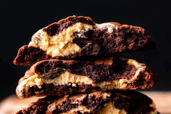 stack of peanut butter filled brownie cookies broken in half