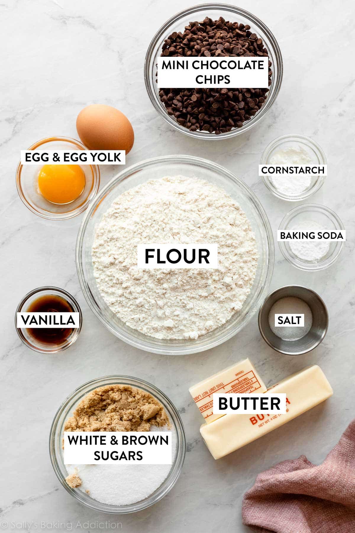 ingredients displayed in bowls including flour, sugar, baking soda, cornstarch, vanilla, salt, plus butter and egg.