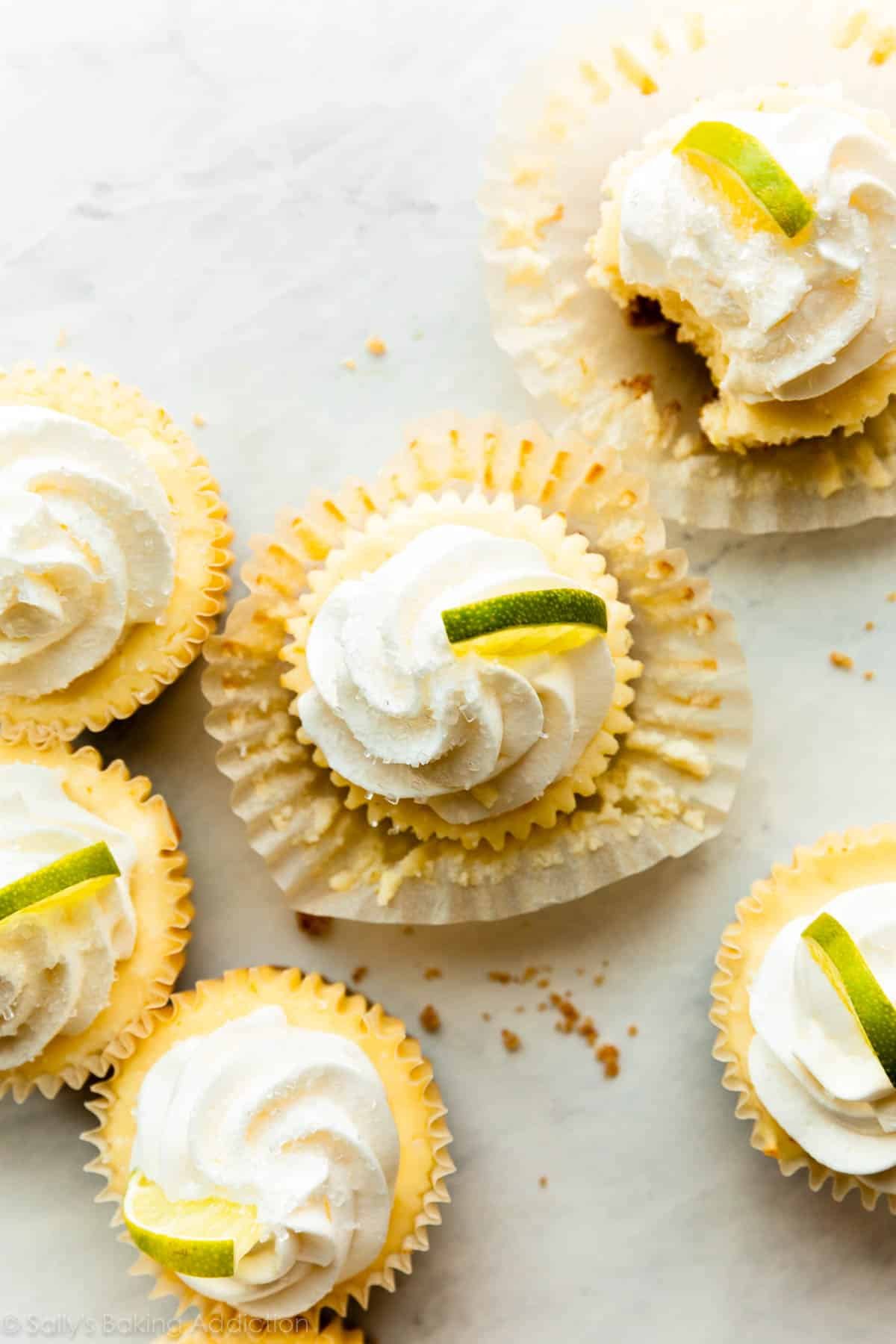 mini margarita cheesecakes with tequila whipped cream and lime slices.