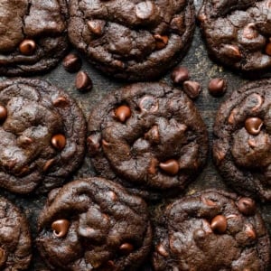 overhead photo of double chocolate chip cookies on black surface.