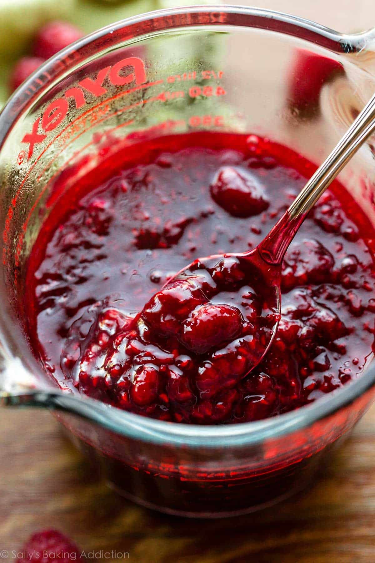 thick and chunky raspberry dessert sauce in liquid measuring cup.