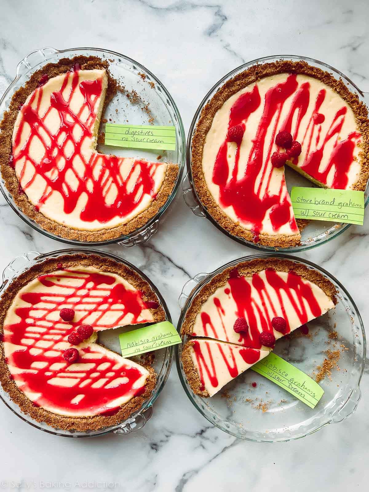 4 cheesecake pies with raspberry sauce and sticky notes on top used for comparison.