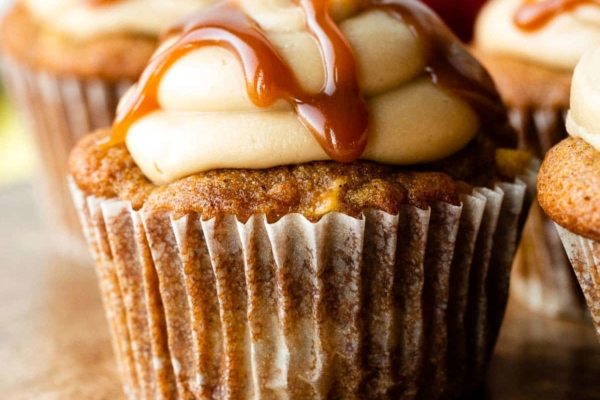 apple cupcake with caramel frosting and salted caramel drizzled on top.
