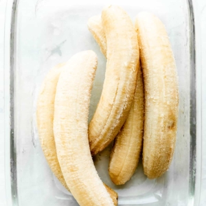 5 frozen bananas in glass rectangle container.