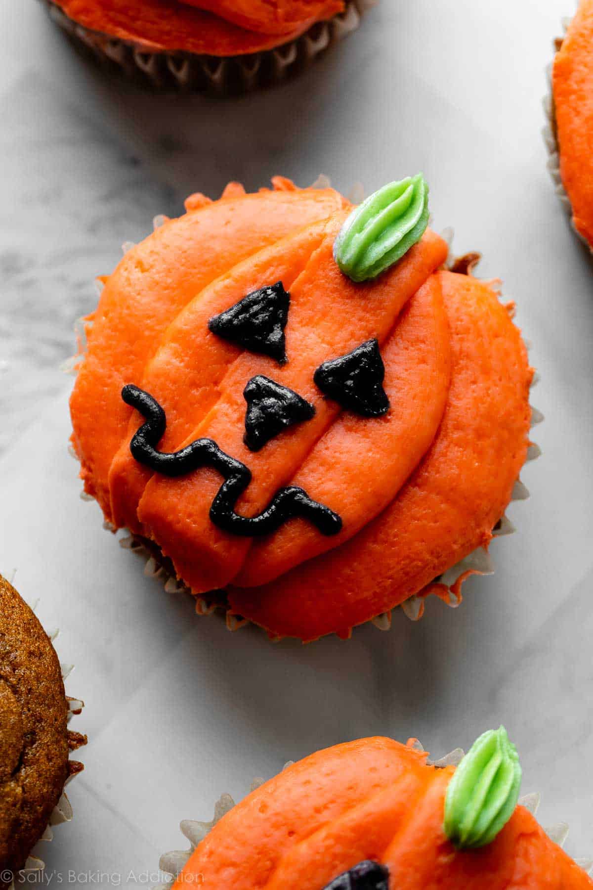 orange jack-o-lantern decorated Halloween cupcake.