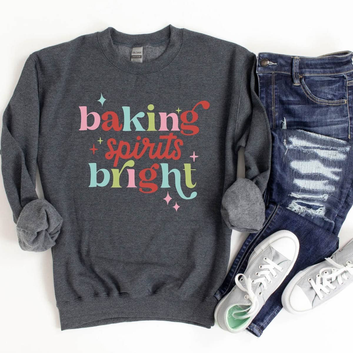 baking spirits bright gray sweatshirt pictured with white sneakers and jeans.