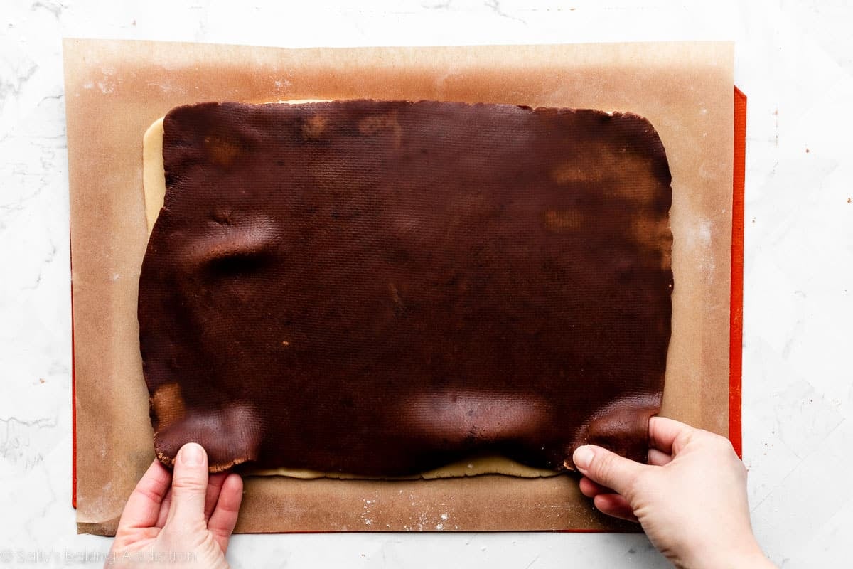 fitting chocolate dough on top of vanilla dough on top of parchment paper.