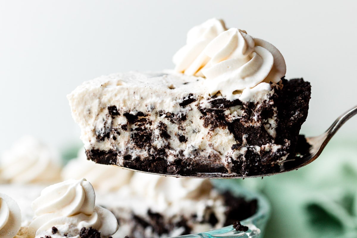 slice of Oreo pie on top of Oreo cookie crust with whipped cream on top.
