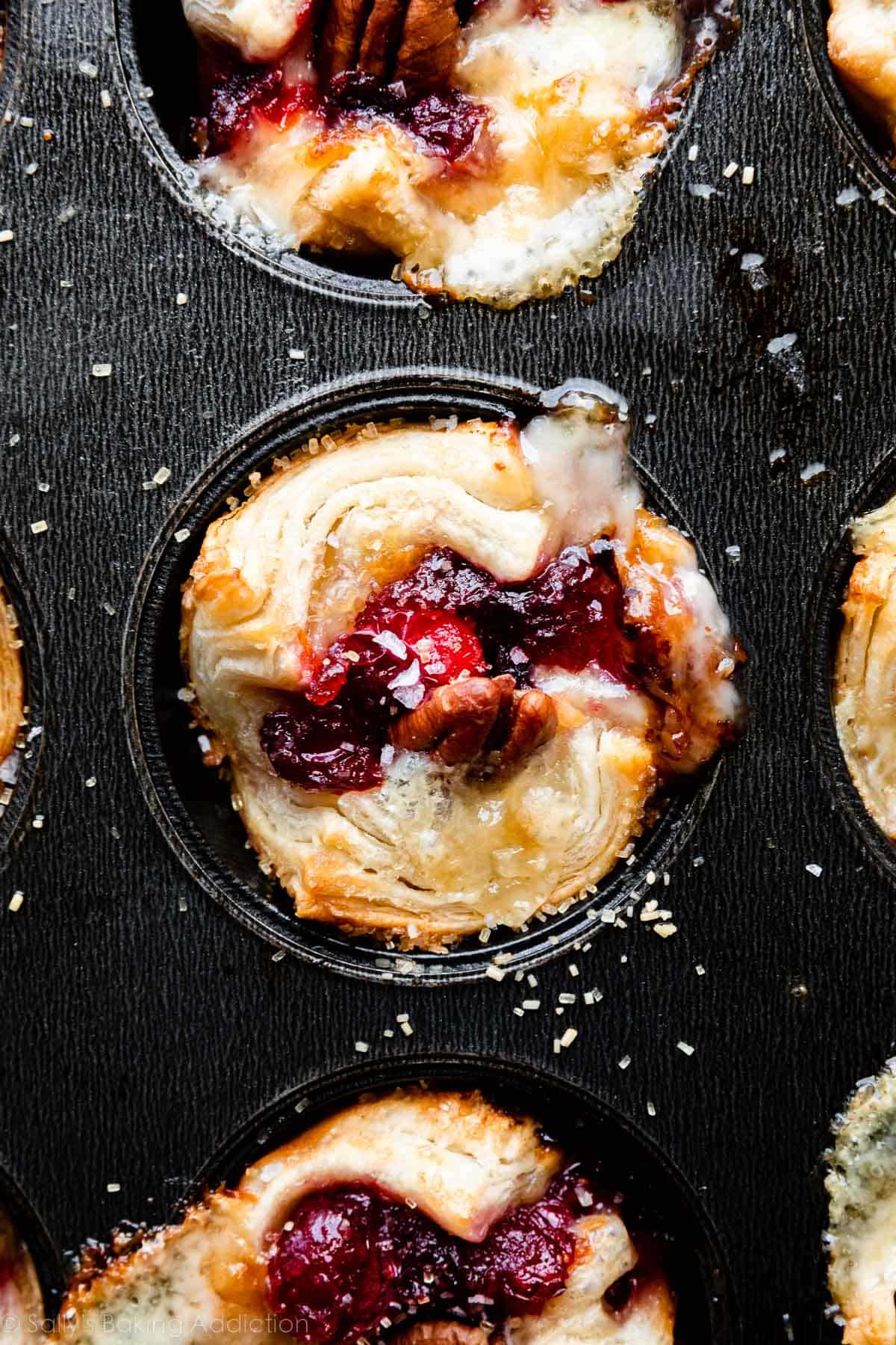 cranberry sauce and brie puff pastry tartlet in muffin pan.
