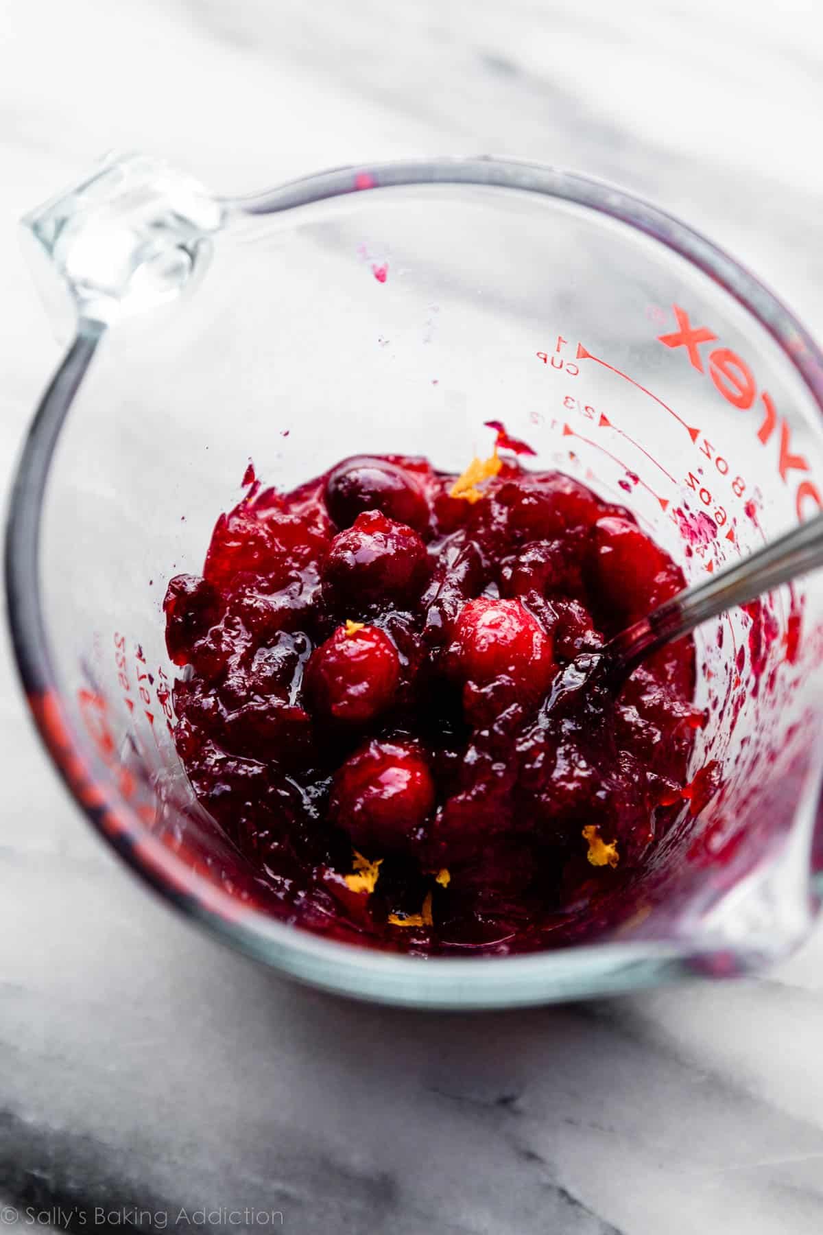 chunky cranberry sauce in liquid measuring cup.