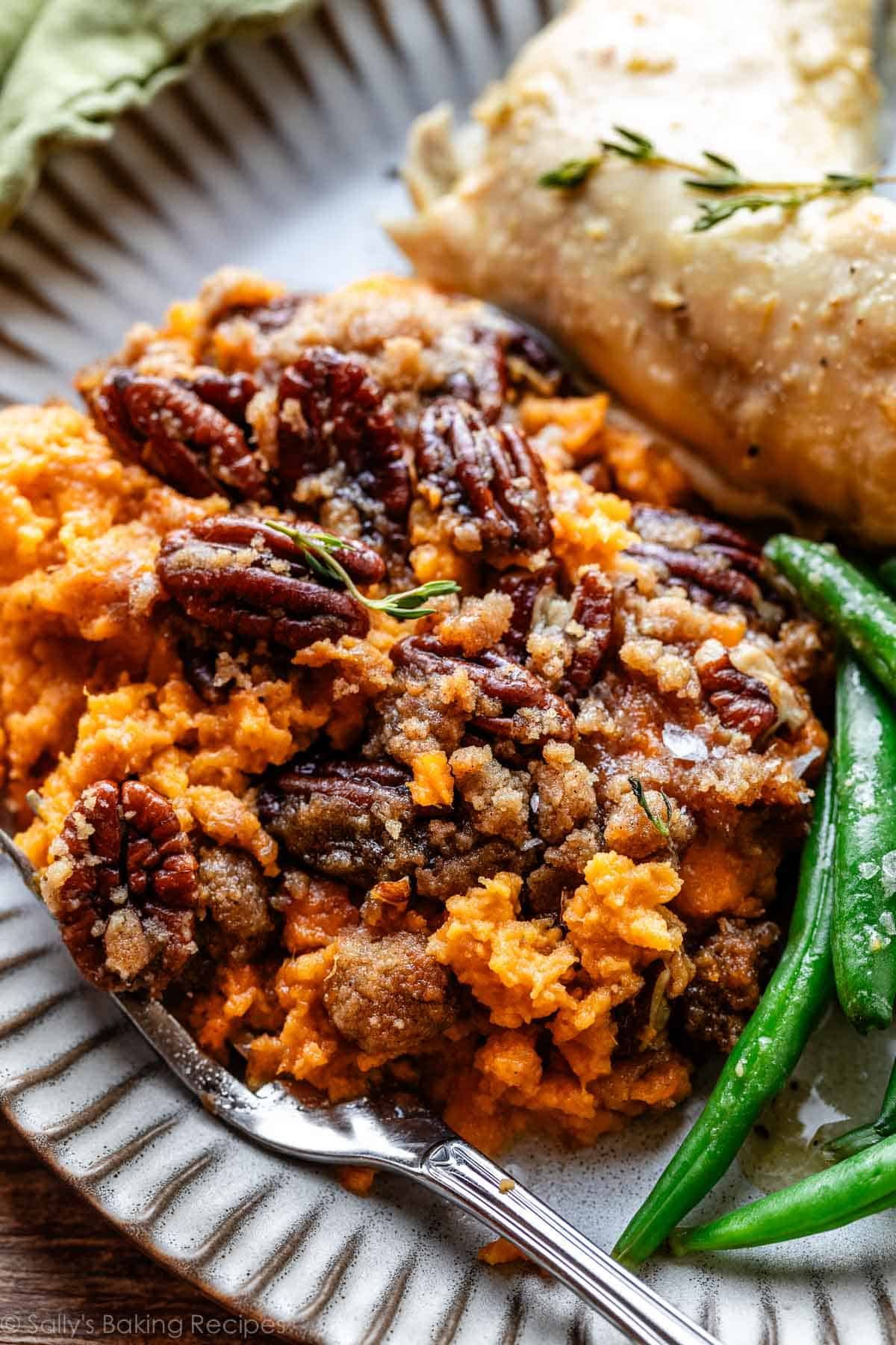 serving of sweet potato casserole on geay plate with turkey and green beans.