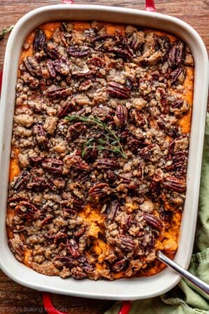 overhead photo of sweet potato casserole with pecan topping with fresh thyme.