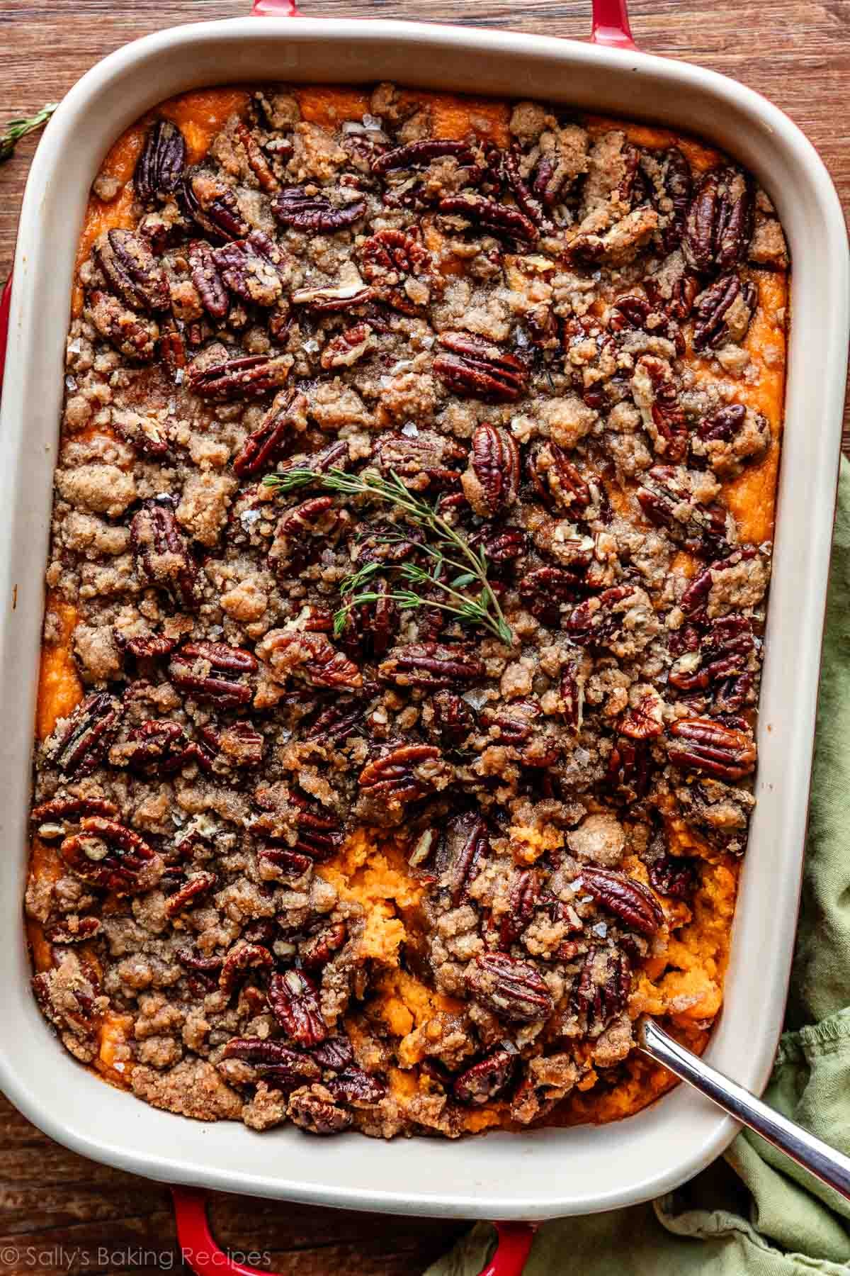 overhead photo of sweet potato casserole with pecan topping with fresh thyme.