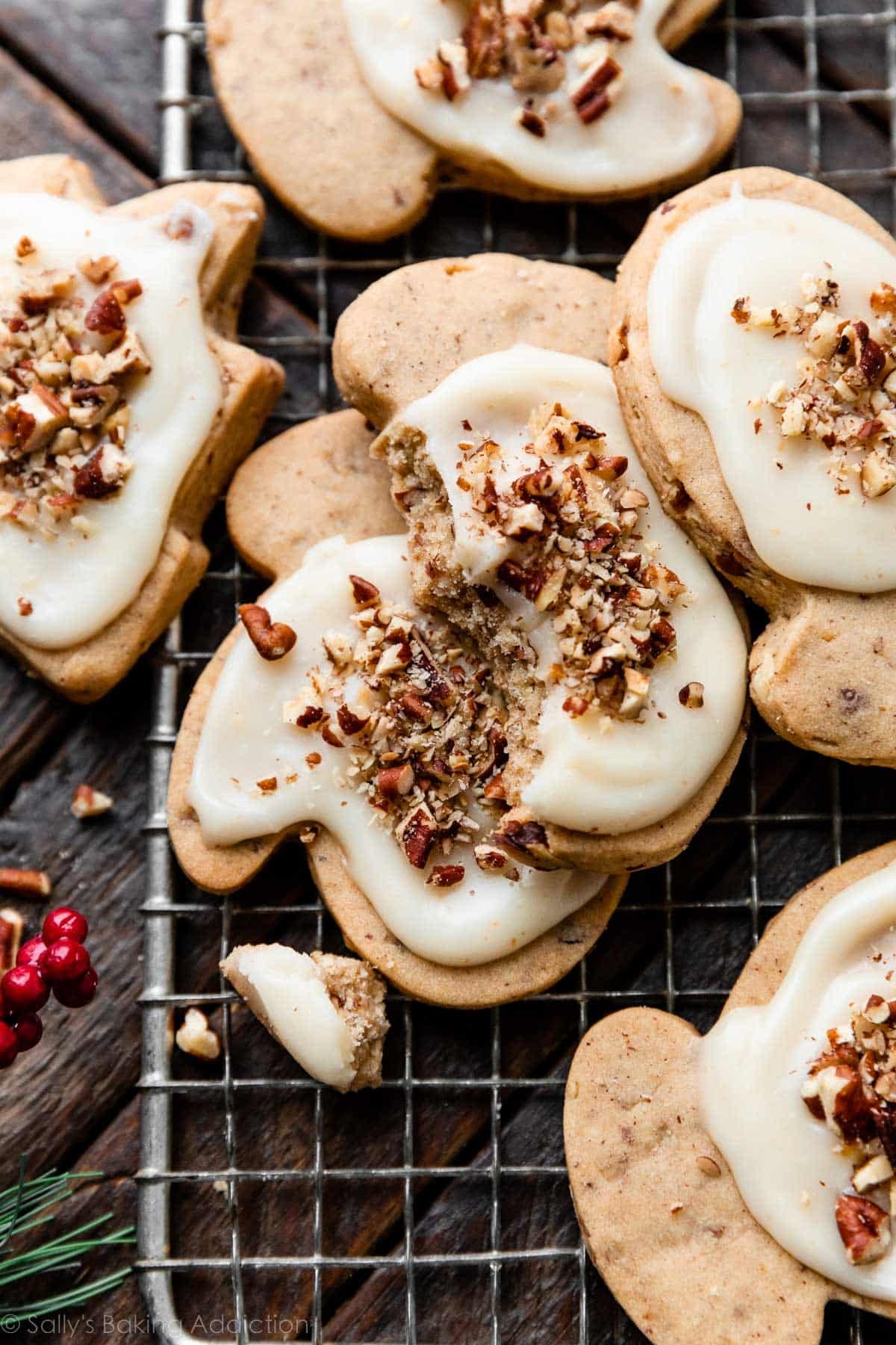 close-up photo of iced pecan sugar cookies with one cookie with a bite taken out.